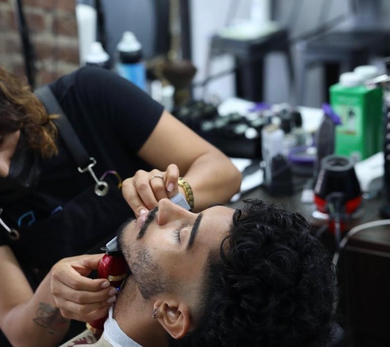 Jessica shaping a client's beard at Jessi G Style